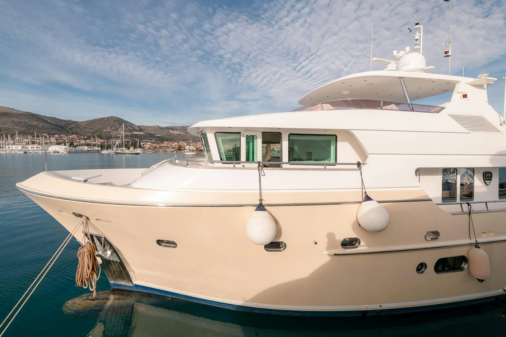 a white boat in a harbor aboard VIRGIN GOLD Yacht for Sale