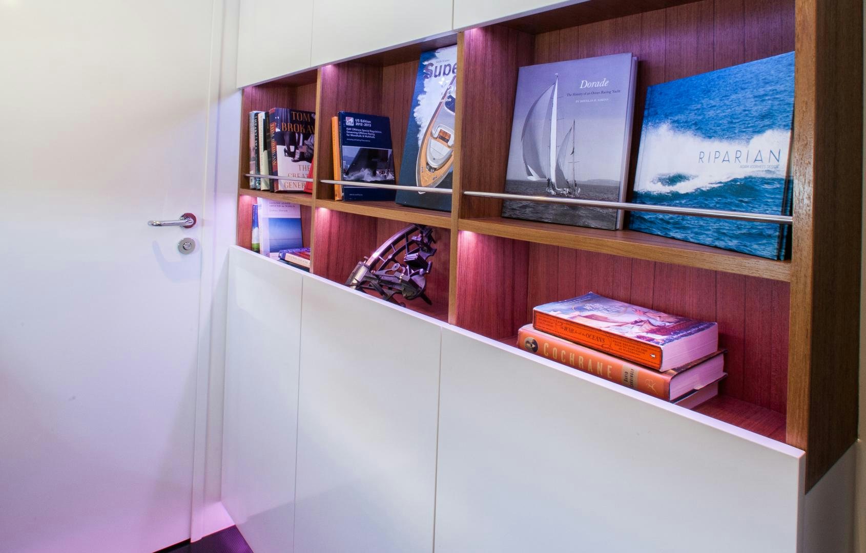 a shelf with books on it aboard AANDEEL Yacht for Sale