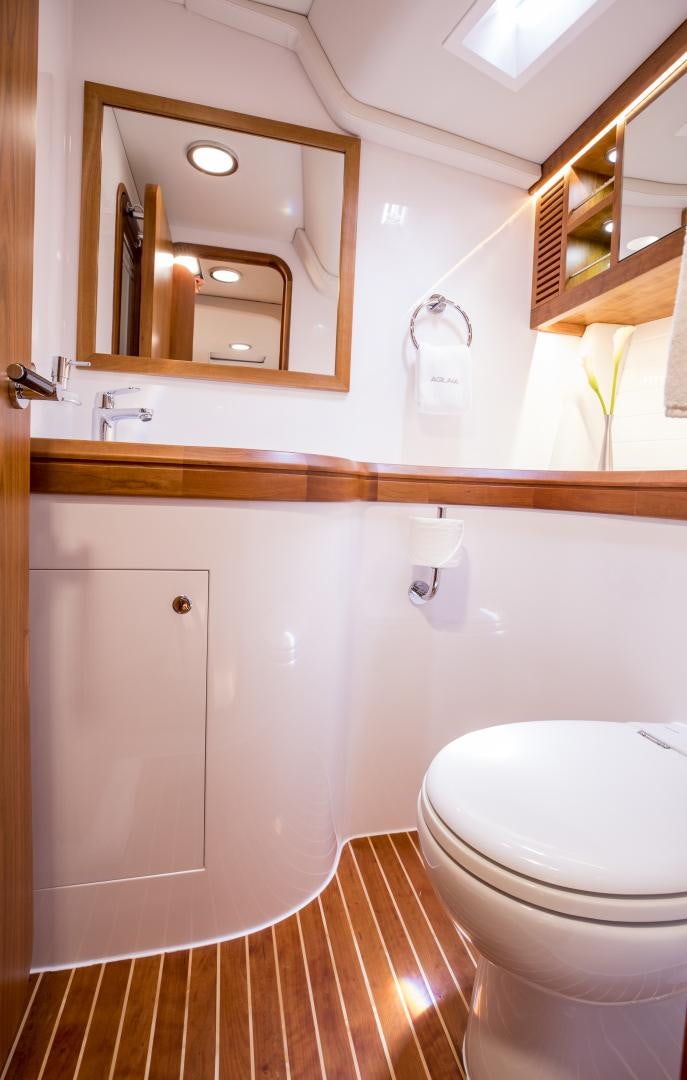 a bathroom with a toilet and a mirror aboard aglaia Yacht for Sale