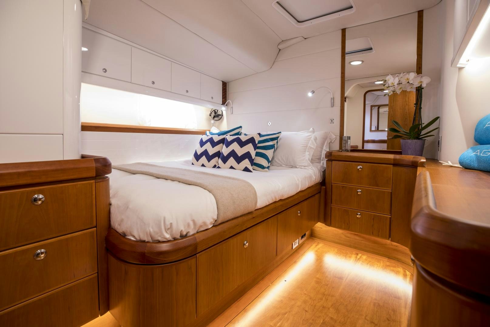 a bedroom with a bed and dresser aboard aglaia Yacht for Sale