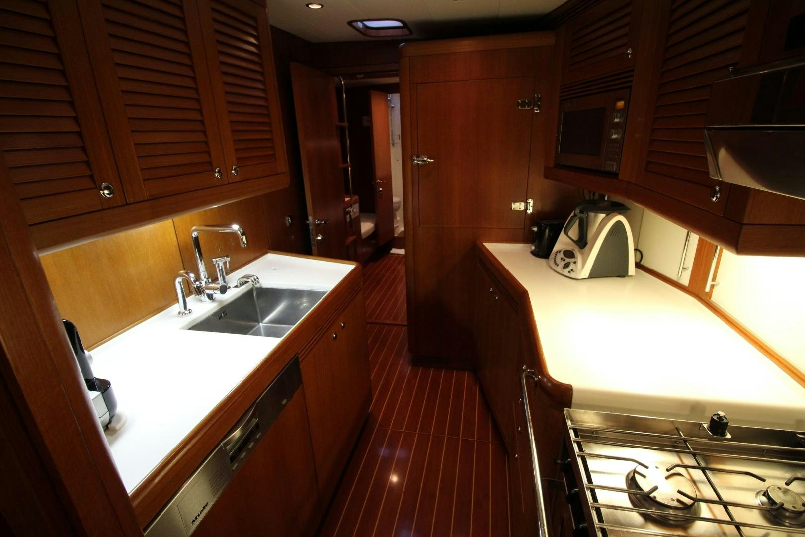 a kitchen with wooden cabinets aboard kiamar Yacht for Sale