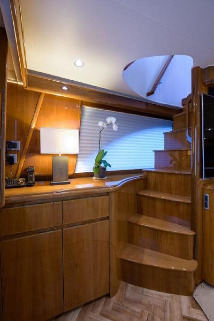 a wooden staircase with a lamp and a window aboard OSH IT Yacht for Sale