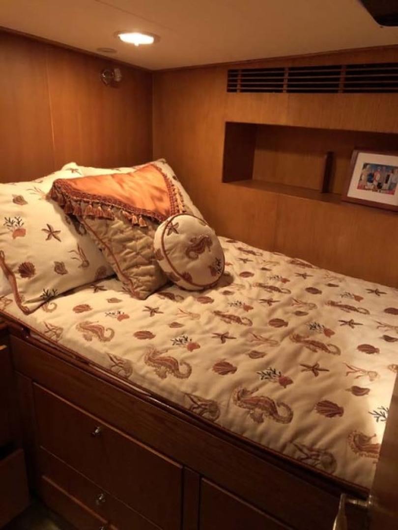 a bed with a pillow and a blanket on it aboard PRIME TIME Yacht for Sale