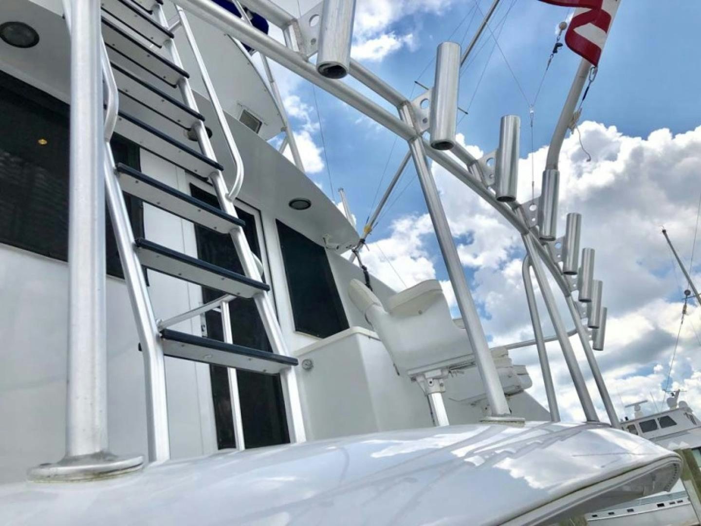 a white boat with a red flag on it aboard PRIME TIME Yacht for Sale