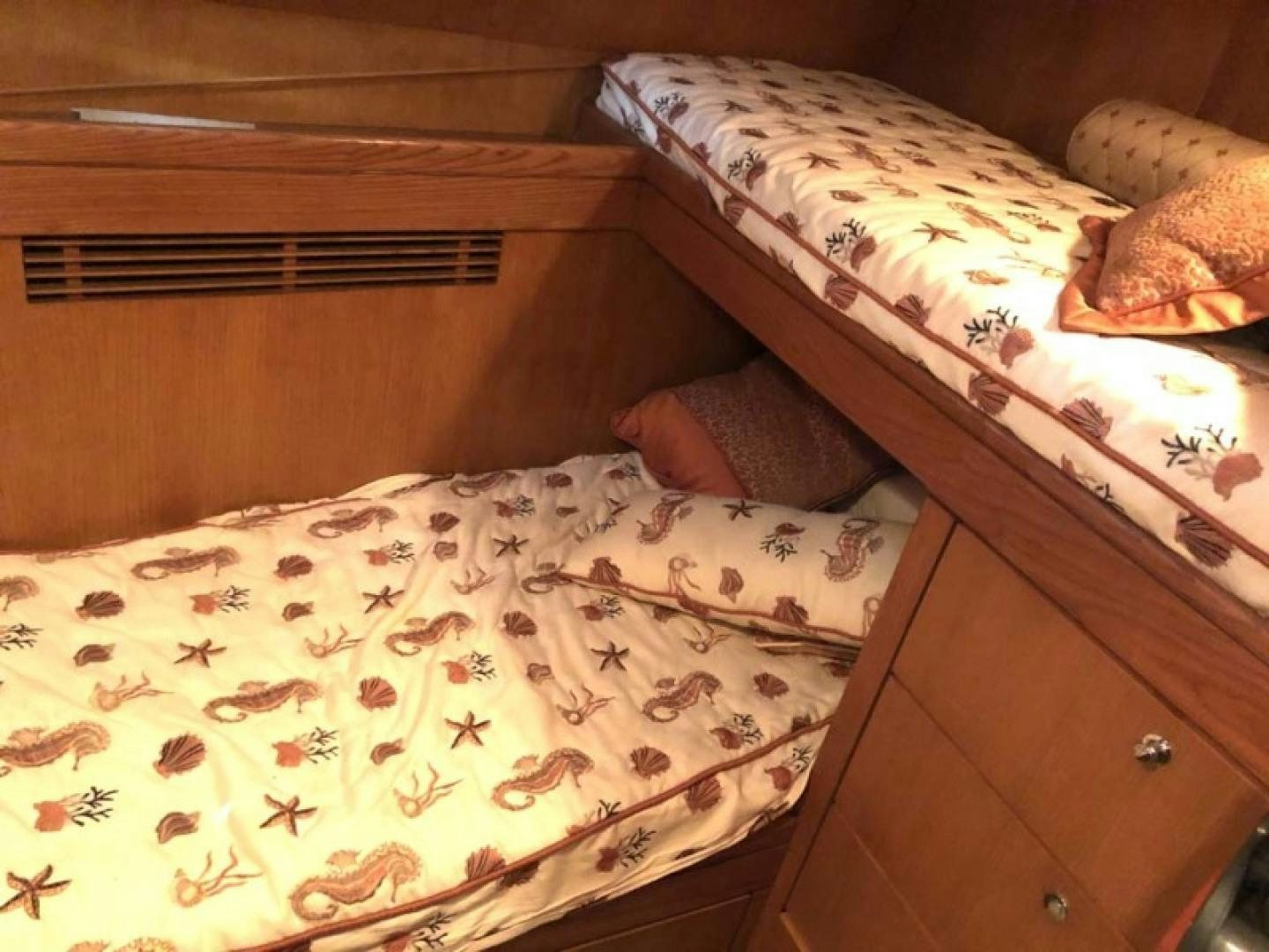 a bed with a colorful comforter aboard PRIME TIME Yacht for Sale