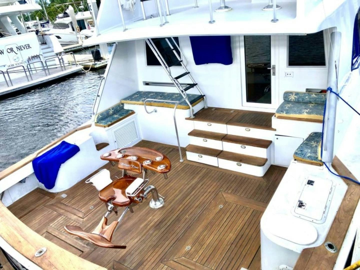 a room with a deck and a table with chairs and a boat aboard PRIME TIME Yacht for Sale