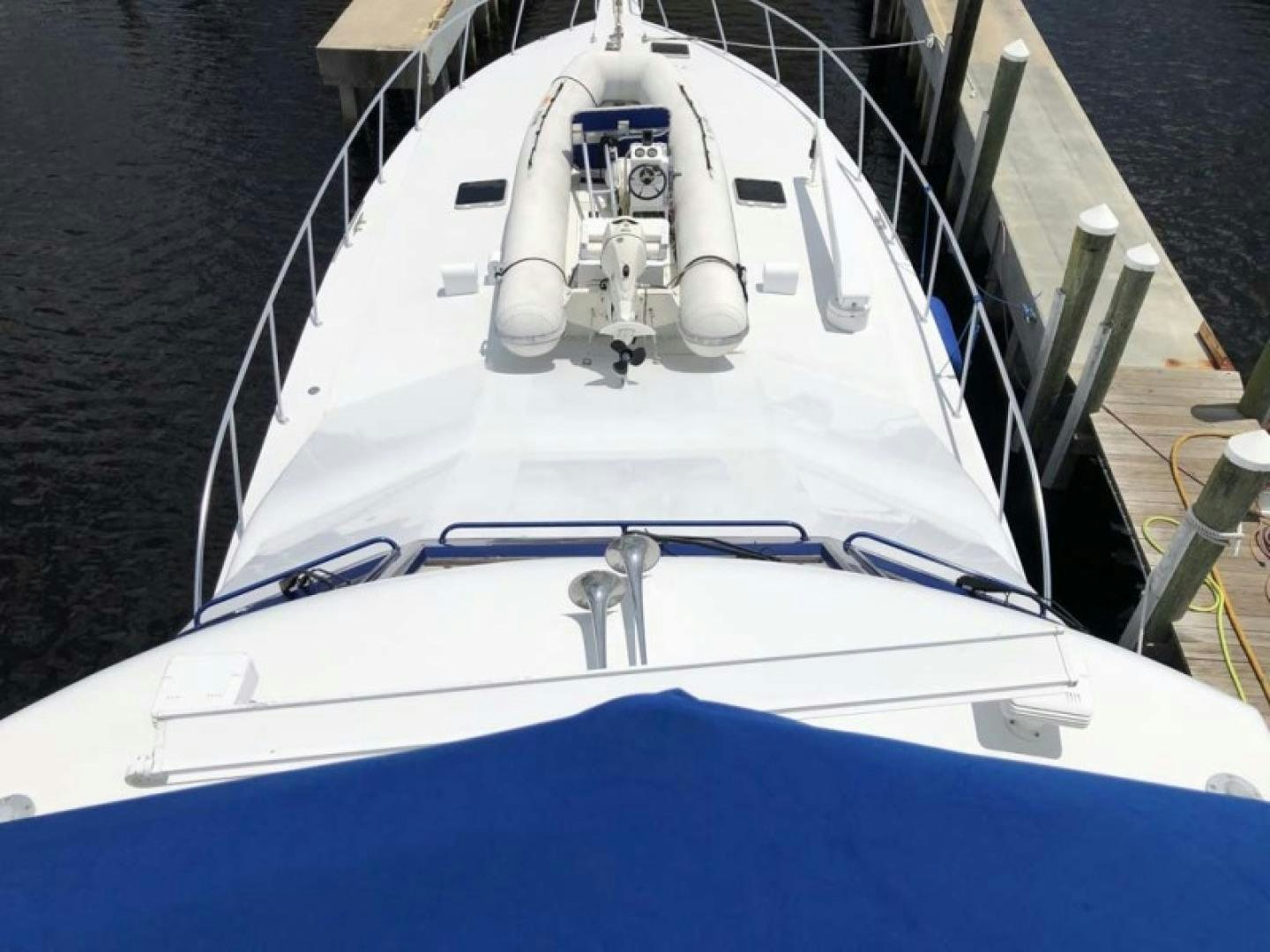 a white boat with a blue stripe aboard PRIME TIME Yacht for Sale