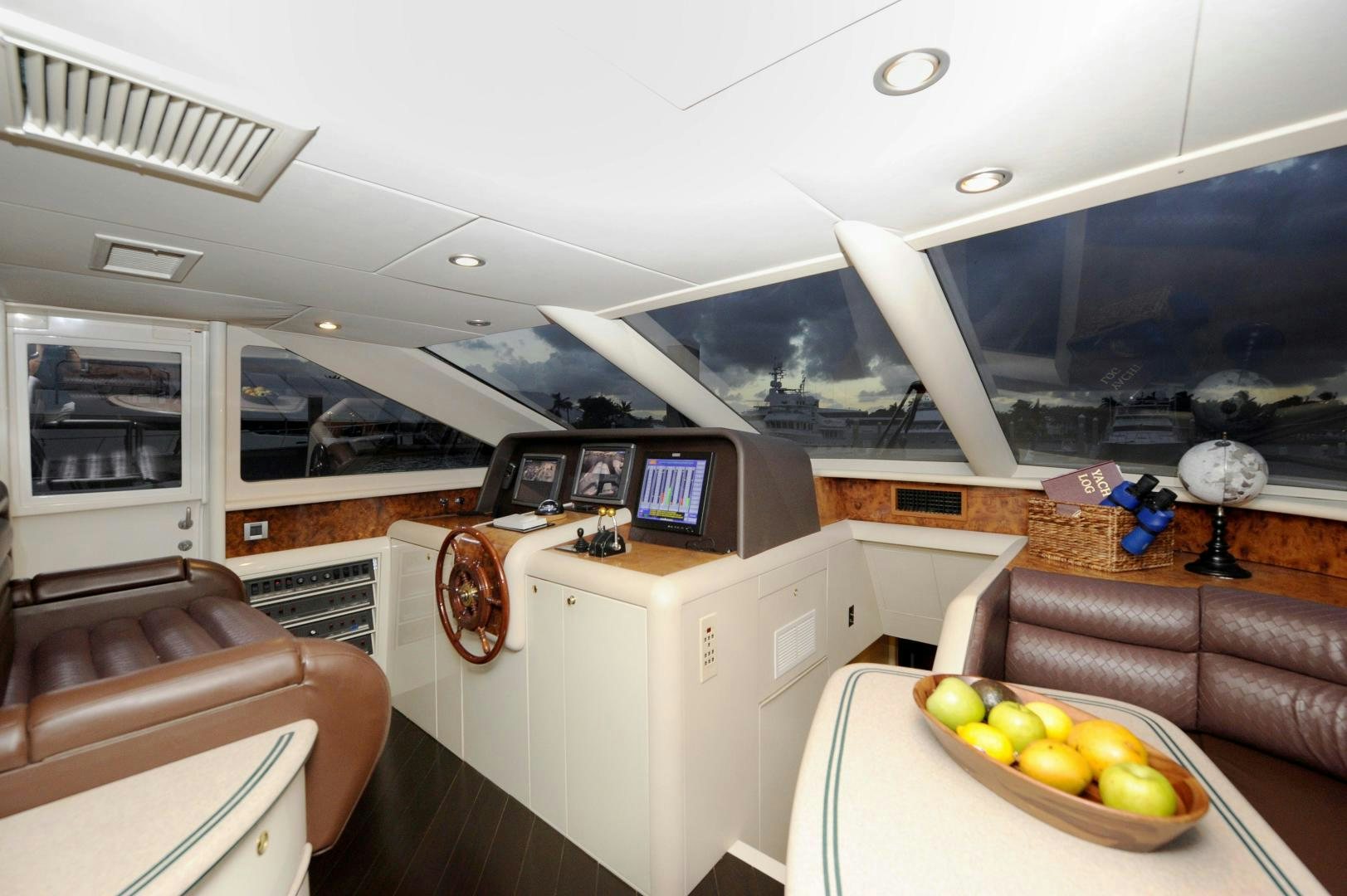 a room with a couch and a table with a bowl of fruit aboard PLAN B Yacht for Sale