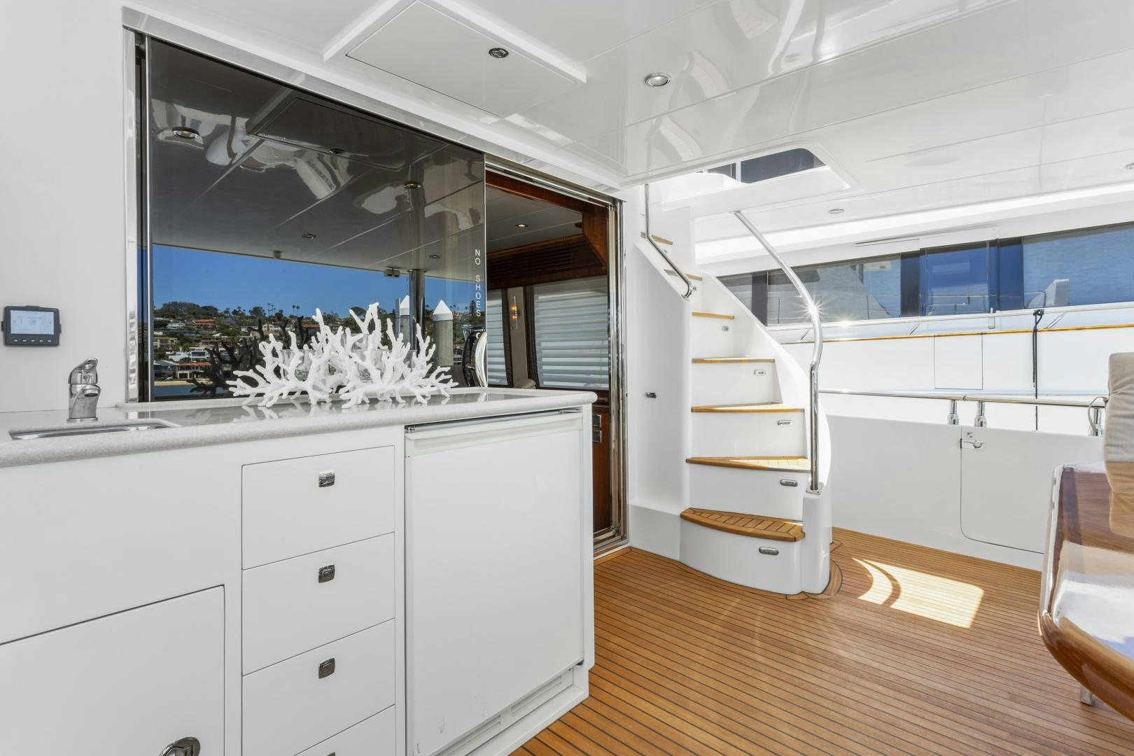 a room with a white shelf and a white cabinet with drawers aboard ODYSEA Yacht for Sale