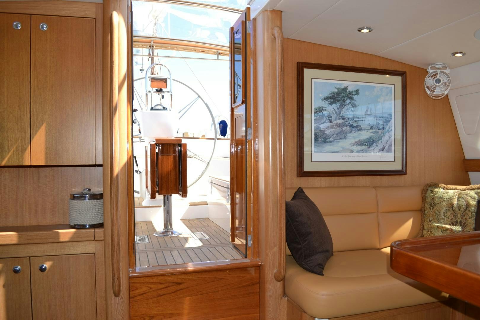 a living room with a wood cabinet and a mirror aboard MEHETABEL Yacht for Sale