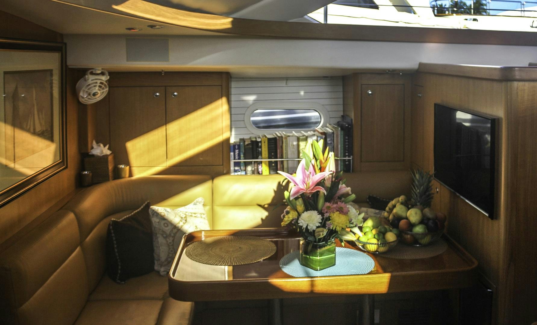 a living room with a table and a tv aboard MEHETABEL Yacht for Sale