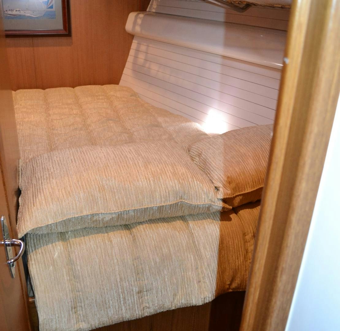 a bed with a white sheet aboard MEHETABEL Yacht for Sale