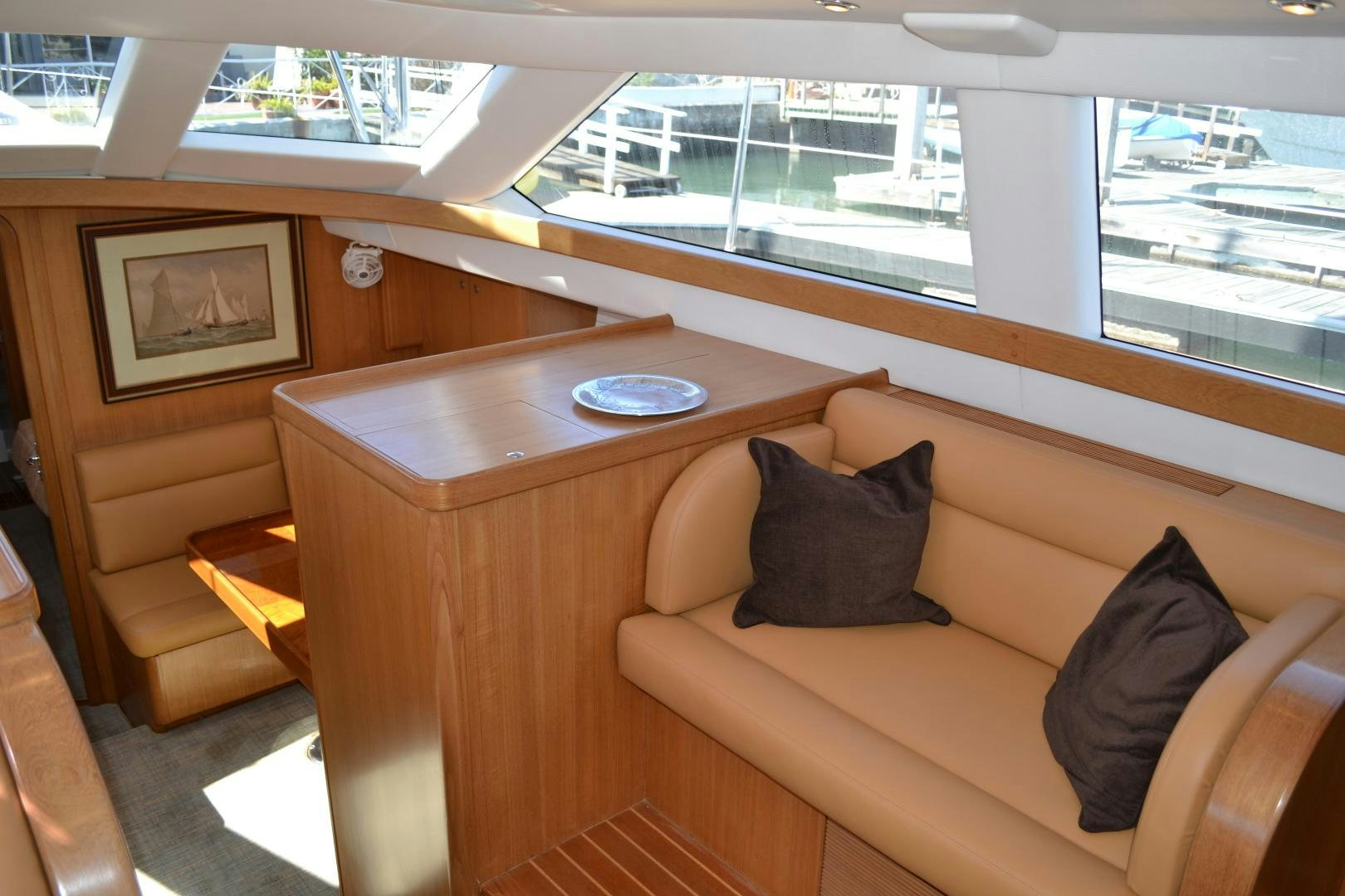 a couch and a table in a room with a window aboard MEHETABEL Yacht for Sale