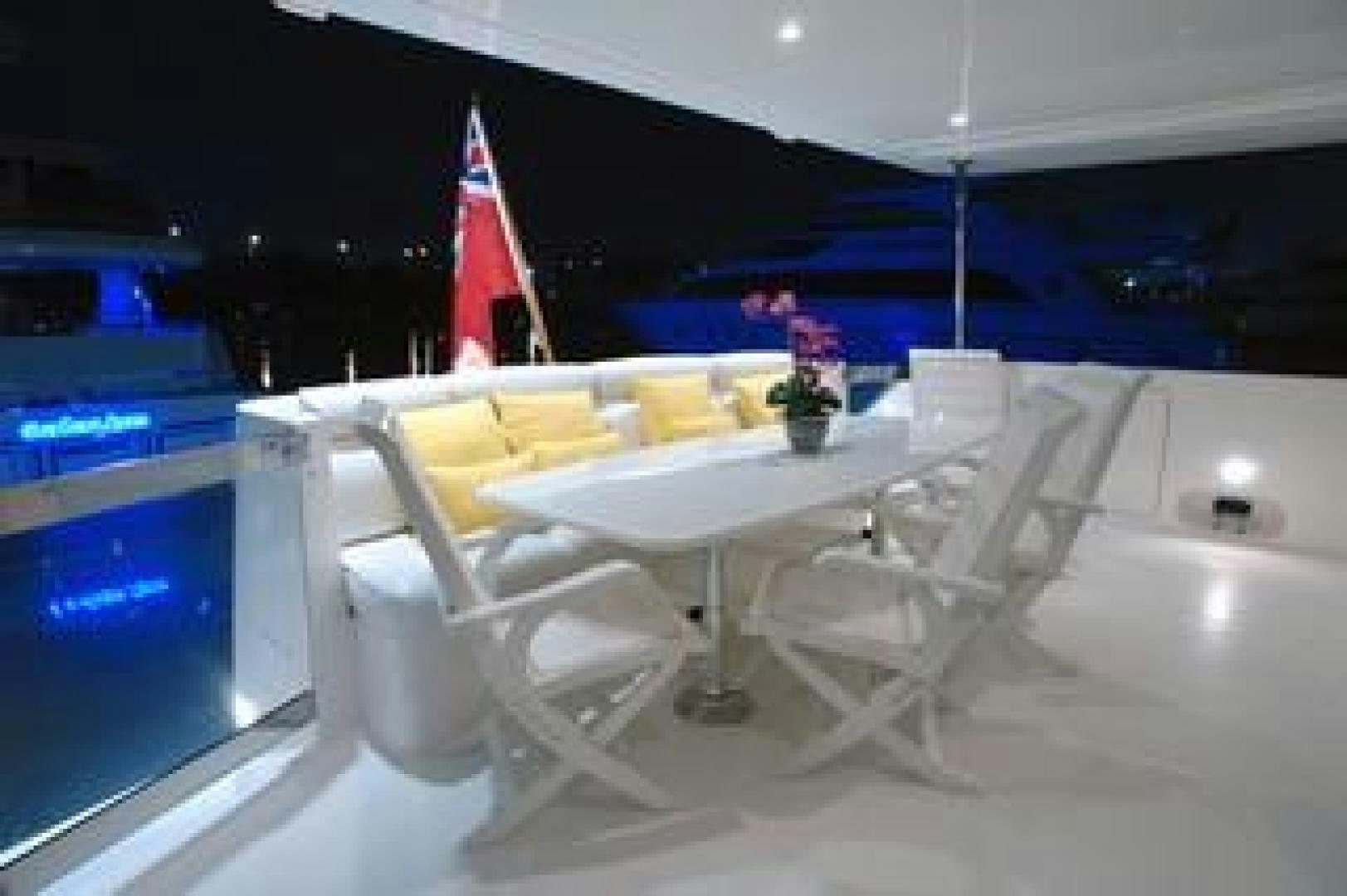 a white table with chairs and a flag on it aboard No Name Yacht for Sale
