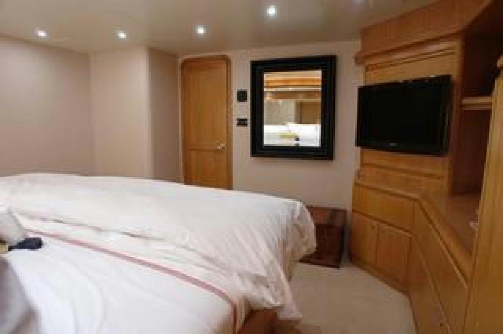 a bedroom with a bed and tv aboard No Name Yacht for Sale