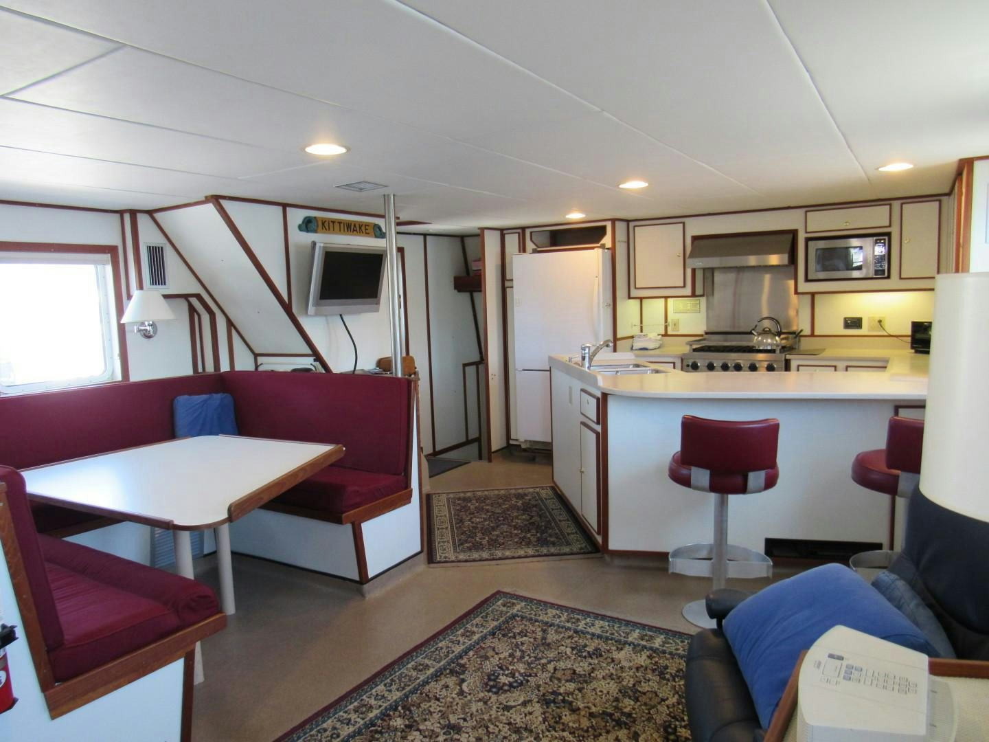 a kitchen with pink chairs aboard KITTIWAKE Yacht for Sale