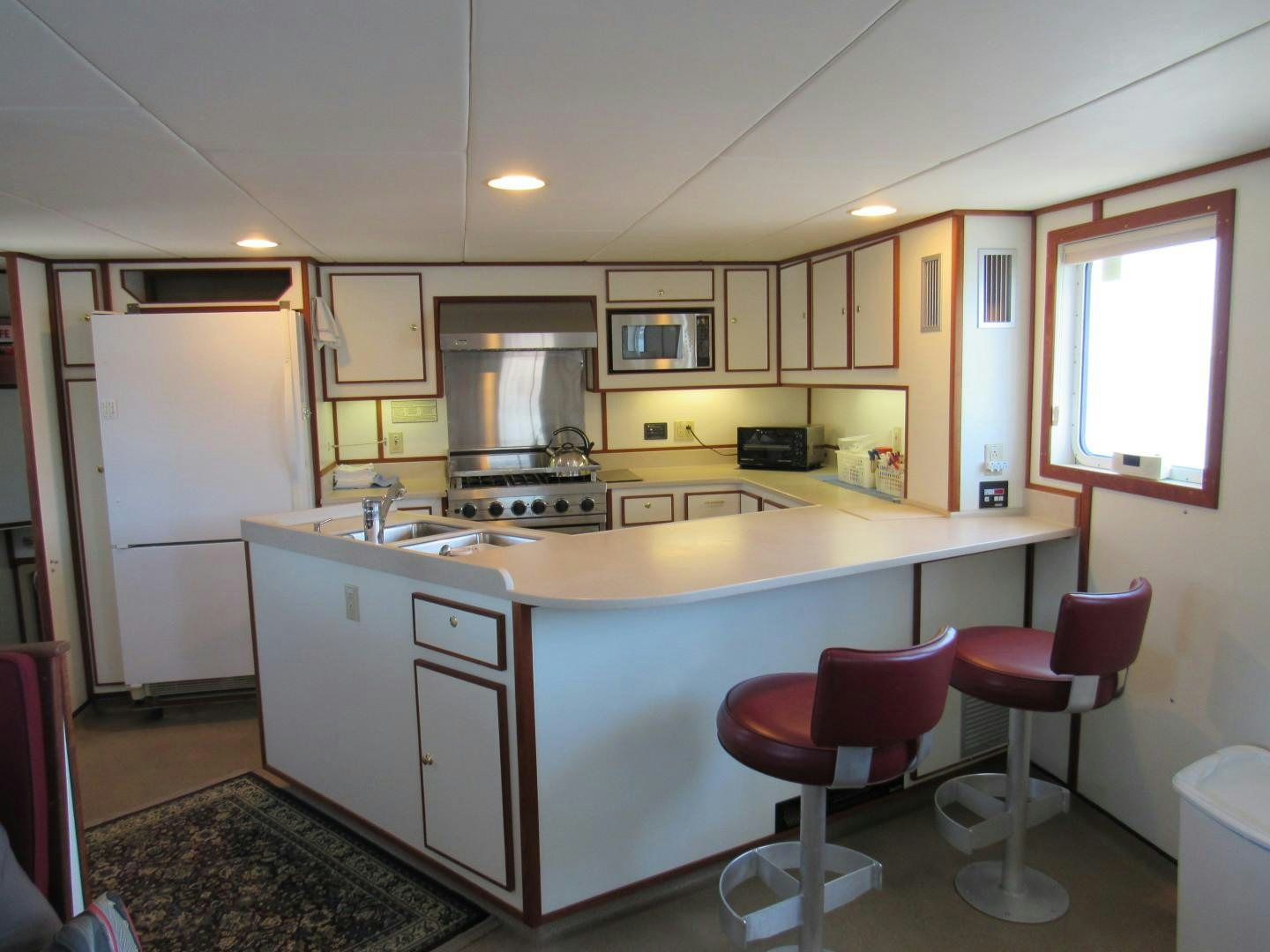 a kitchen with white cabinets aboard KITTIWAKE Yacht for Sale