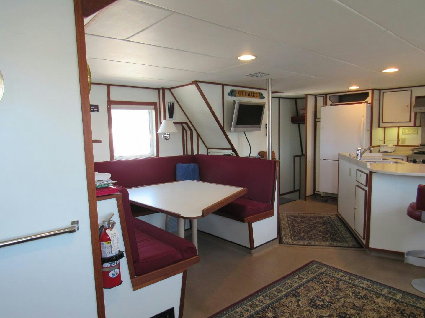 a kitchen with a table and chairs aboard KITTIWAKE Yacht for Sale