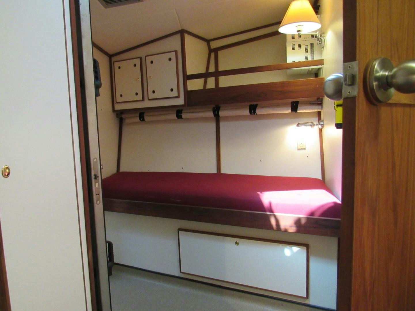 a room with a bed and cabinets aboard KITTIWAKE Yacht for Sale