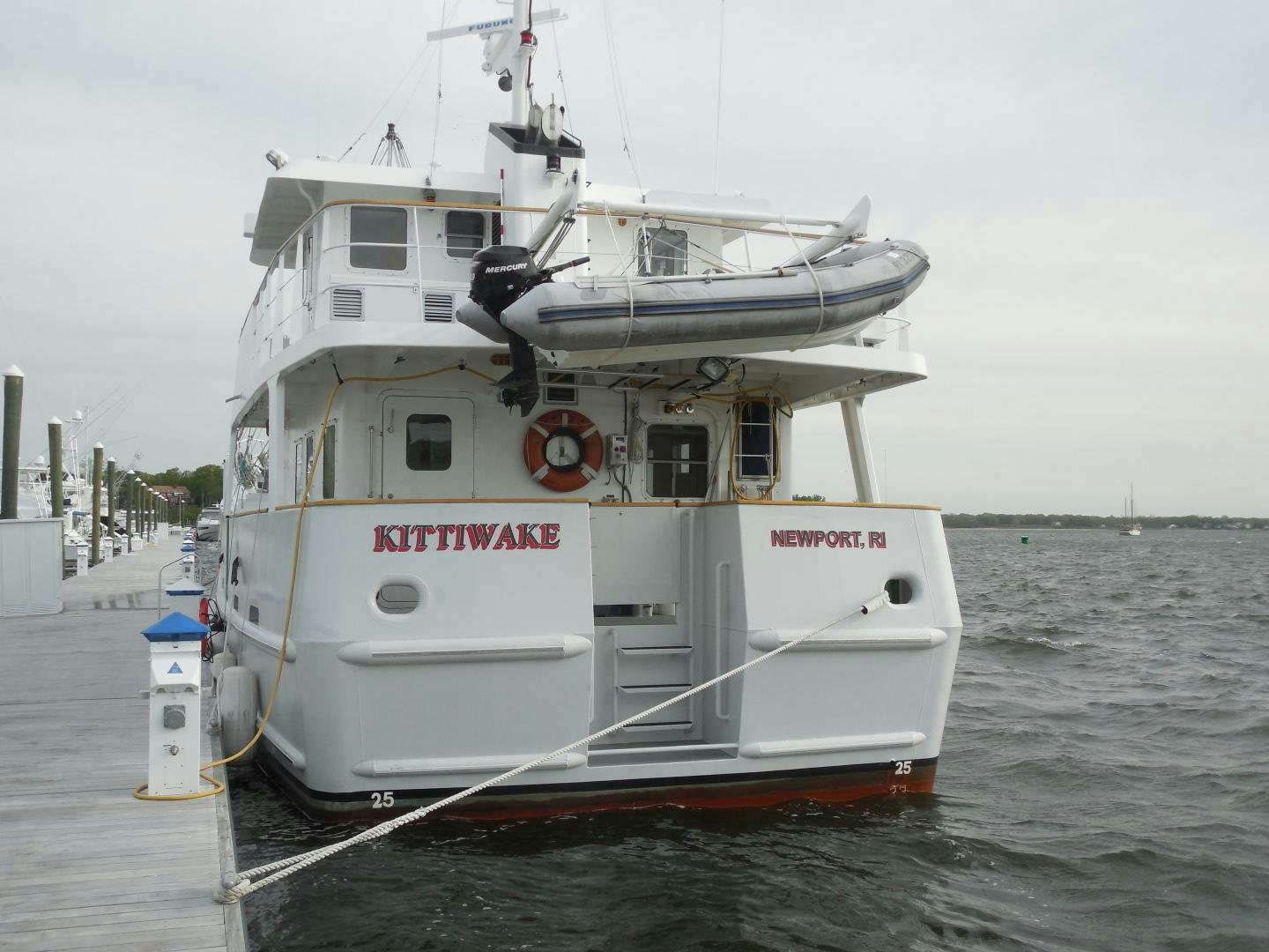 a large white boat in a body of water aboard KITTIWAKE Yacht for Sale