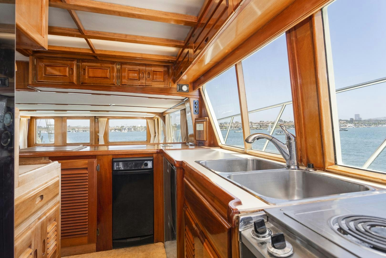 a kitchen with wooden cabinets aboard EL AMO Yacht for Sale