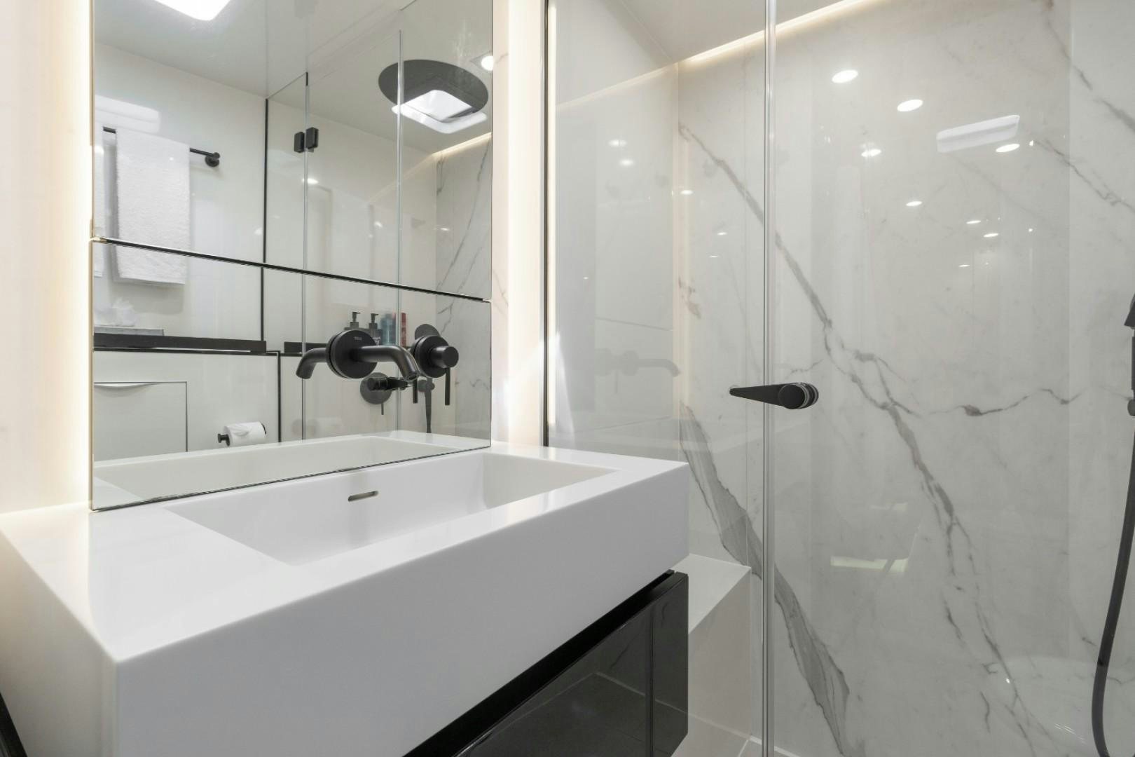 a bathroom with a bathtub and shower aboard OCEAN VIBES Yacht for Sale