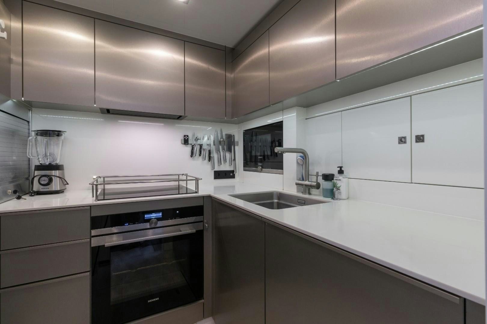 a kitchen with white cabinets aboard OCEAN VIBES Yacht for Sale