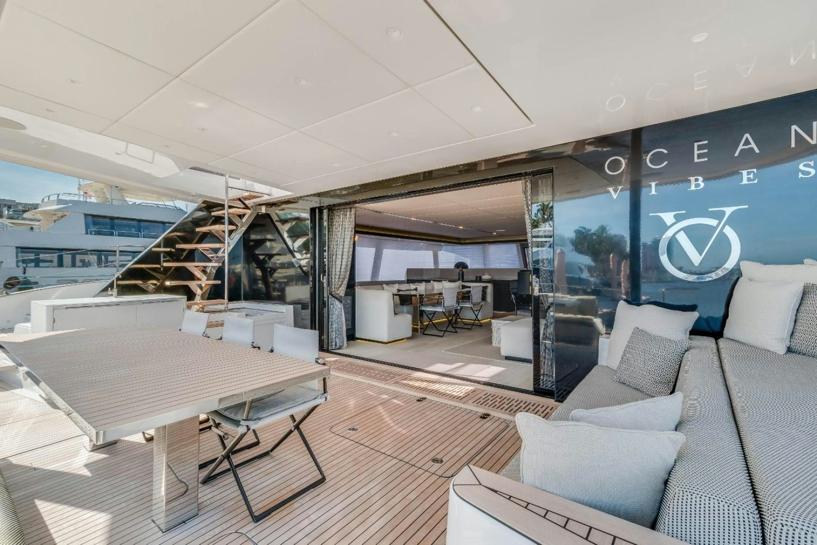 a room with a table and couches aboard OCEAN VIBES Yacht for Sale