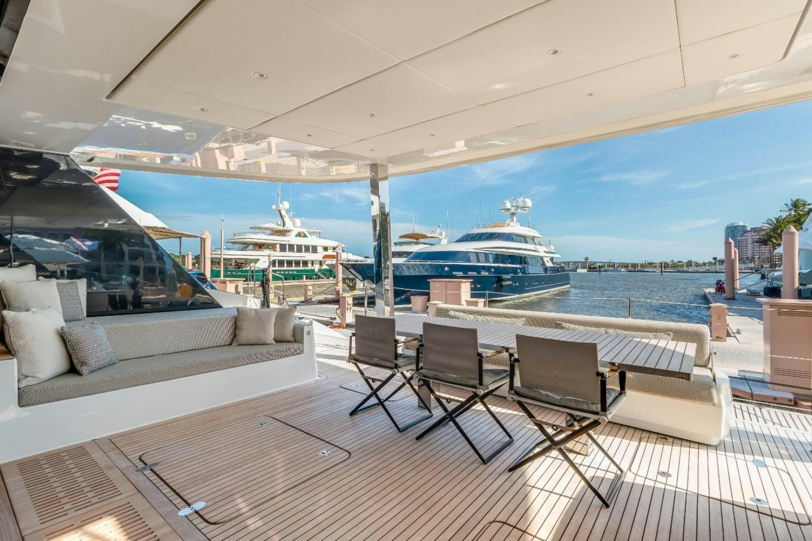 a large patio with chairs and a large cruise ship in the background aboard OCEAN VIBES Yacht for Sale
