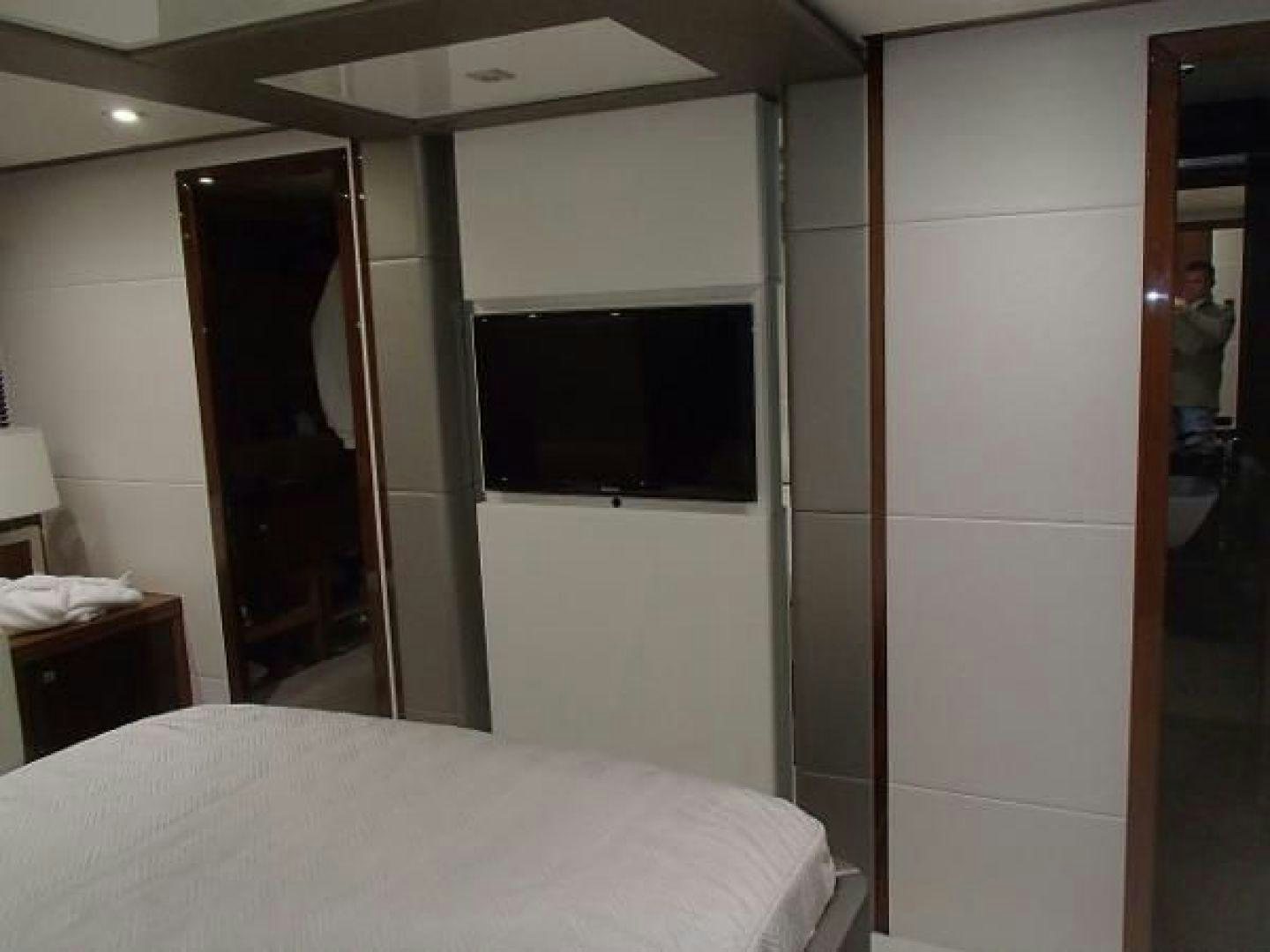 a bedroom with a television on the wall aboard GEMINI Yacht for Sale
