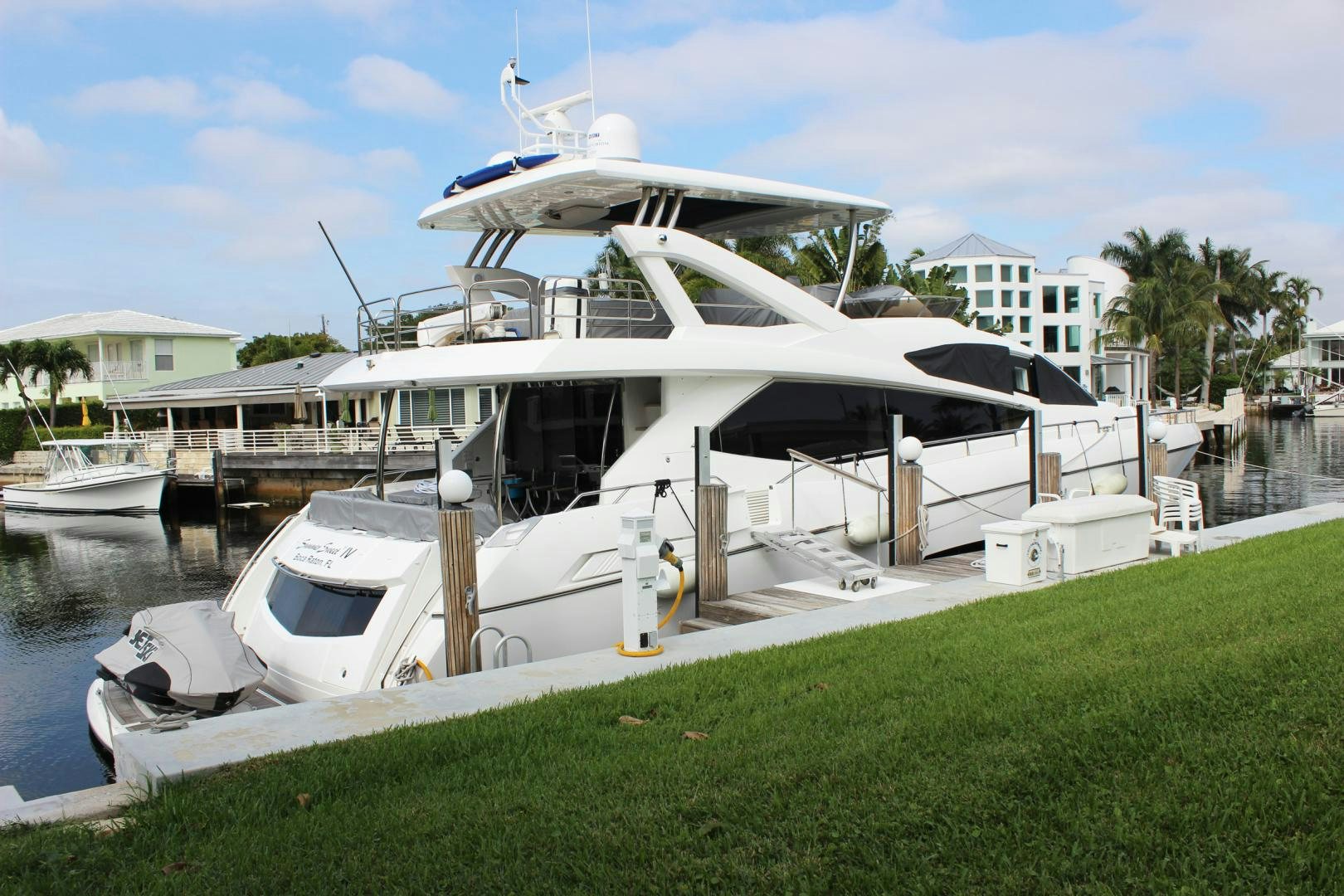 a white boat docked at a pier aboard GEMINI Yacht for Sale