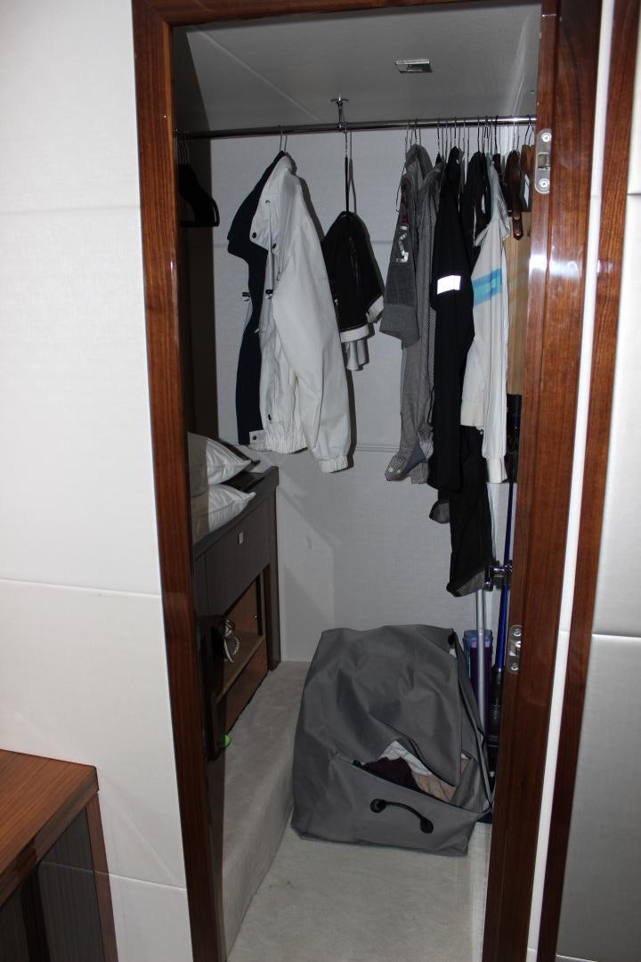 a closet with clothes on the wall aboard GEMINI Yacht for Sale