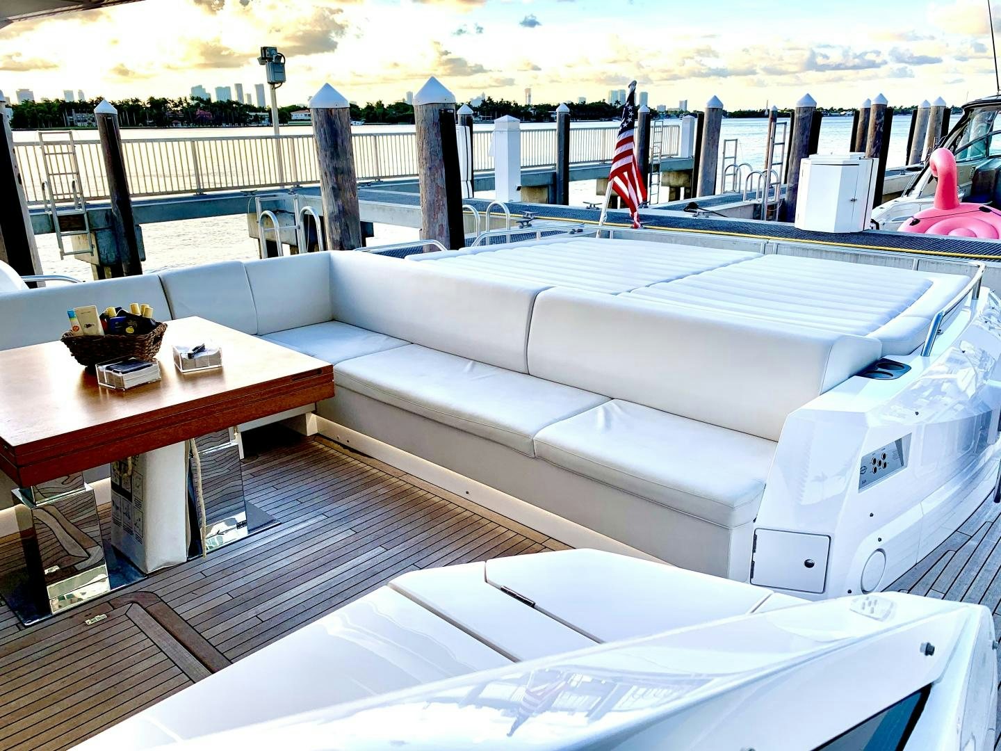 a lounge area with a large white couch and a table with a flag on it aboard STRATEGIC DREAMS Yacht for Sale