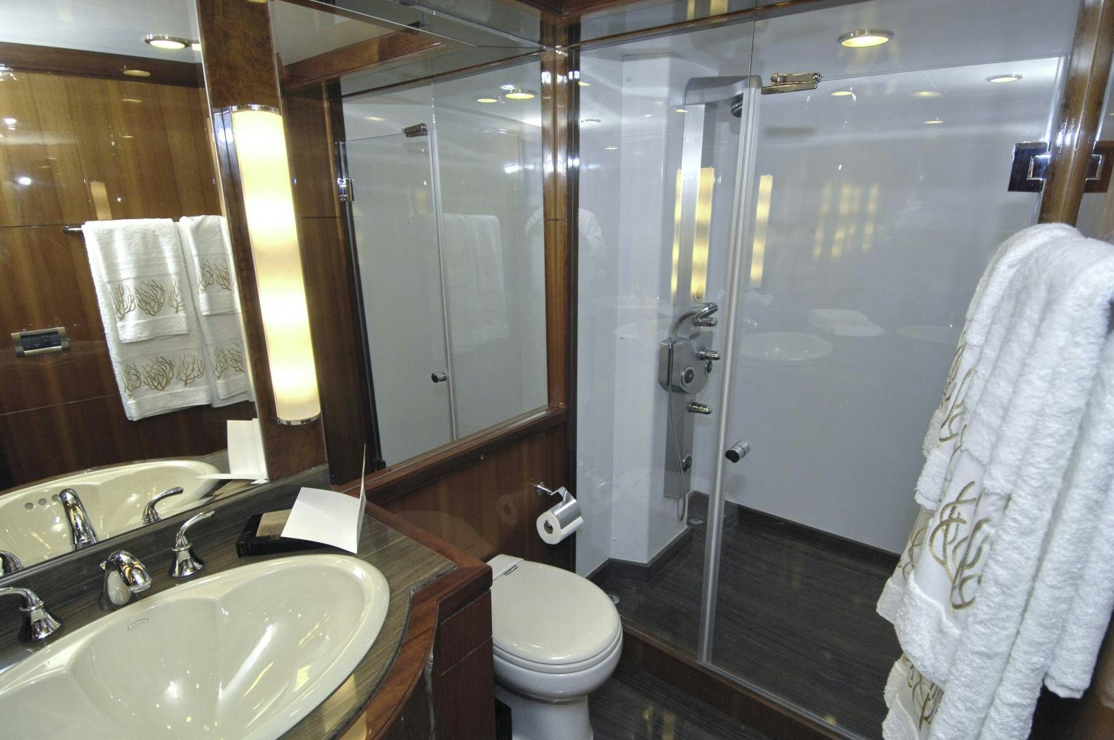 a bathroom with a glass shower door aboard HATT TRICK Yacht for Sale