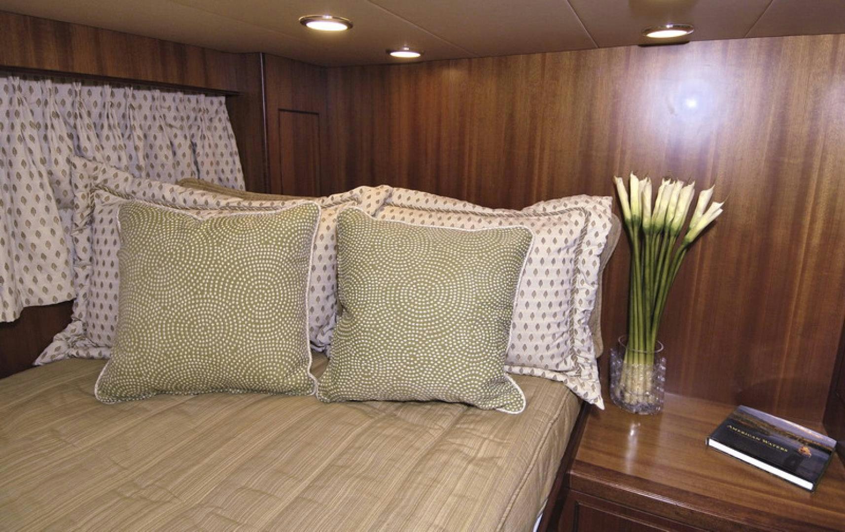 a couch with pillows and a vase of flowers on it aboard HATT TRICK Yacht for Sale