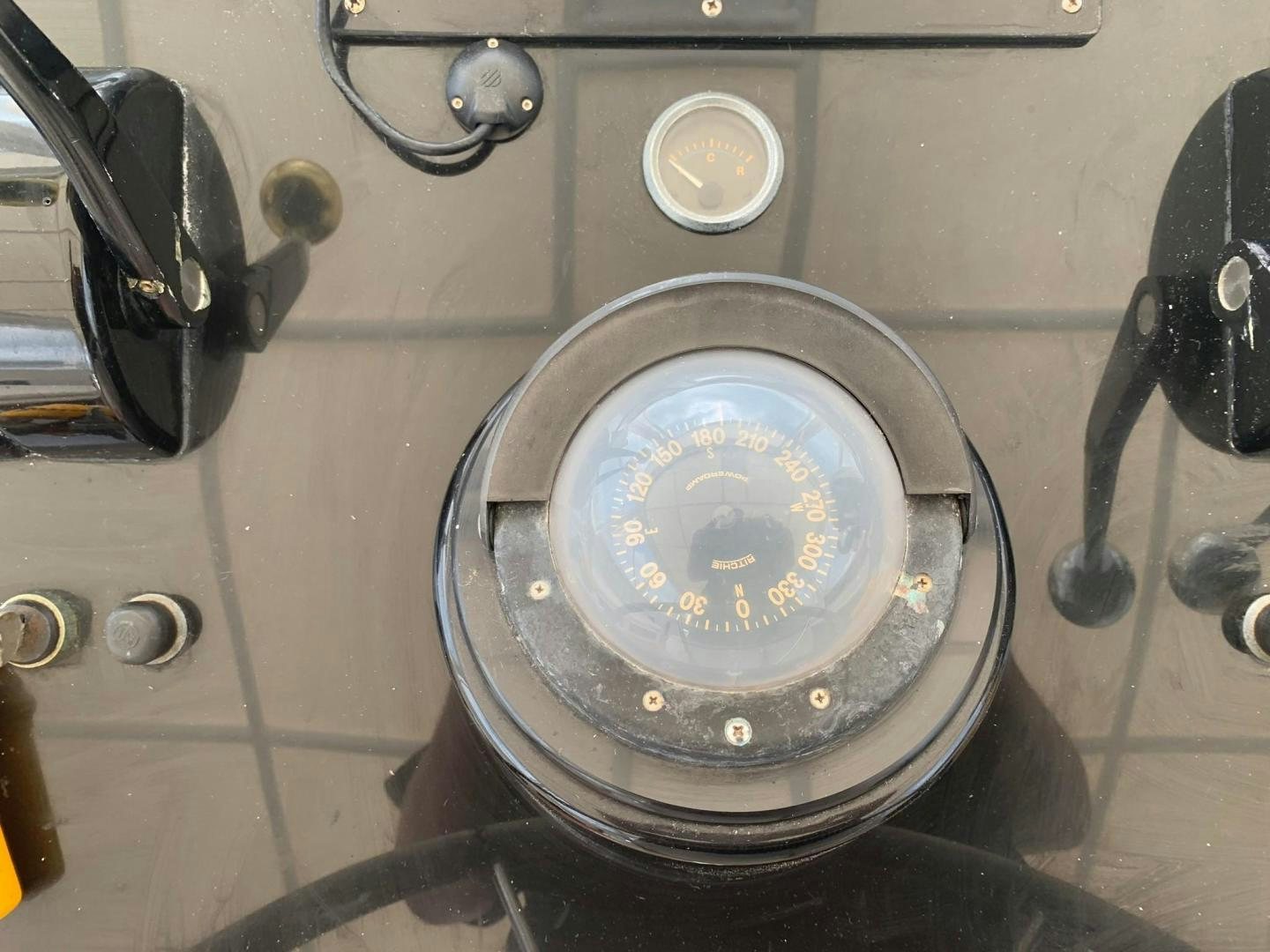 a round clock on a metal surface aboard No Name Yacht for Sale