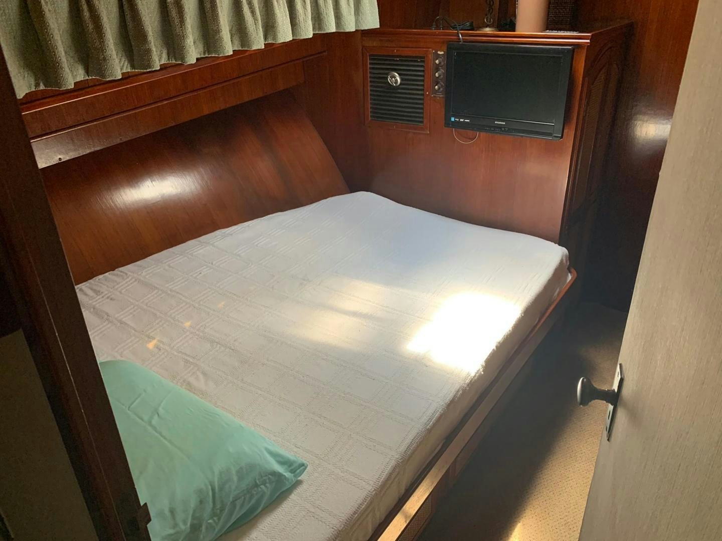 a bed with a television on top of it aboard No Name Yacht for Sale