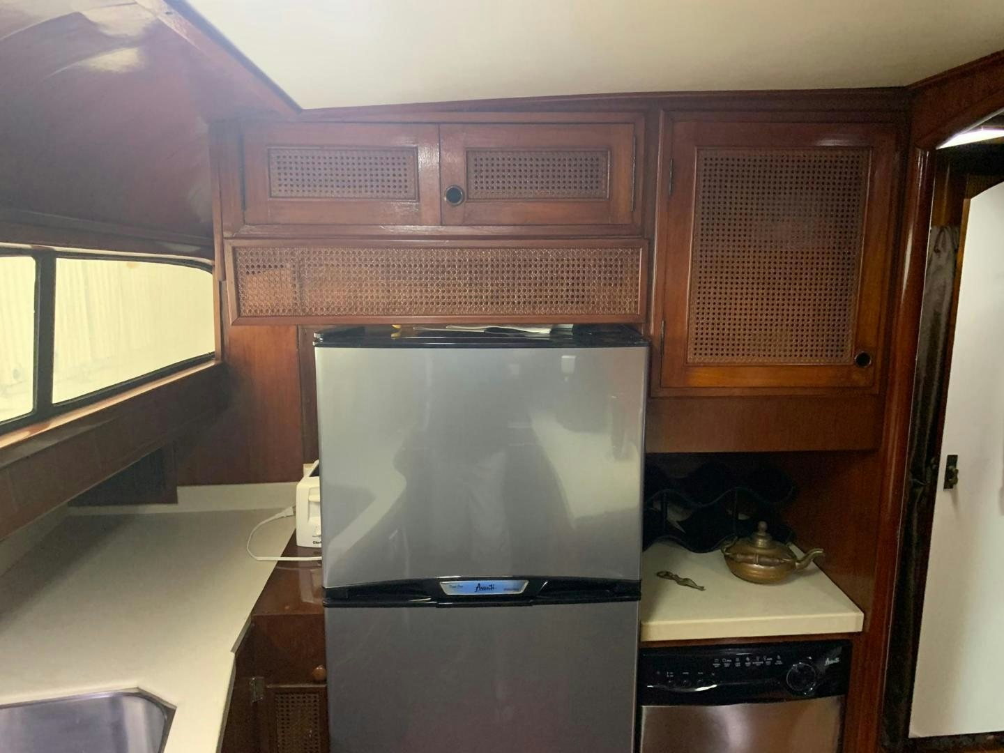 a kitchen with a refrigerator and microwave aboard No Name Yacht for Sale