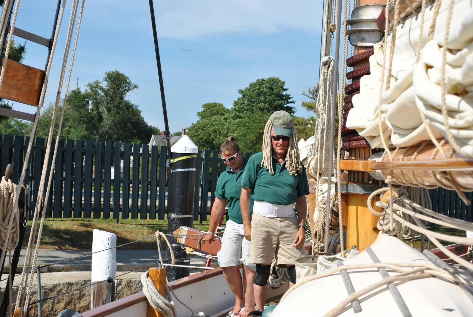 a man and woman standing next to a boat aboard TREE OF LIFE Yacht for Sale