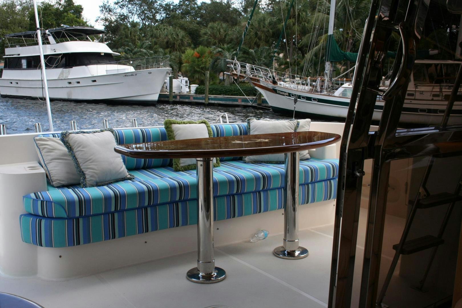 a couch on a table by a body of water aboard UNSINKABLE II Yacht for Sale