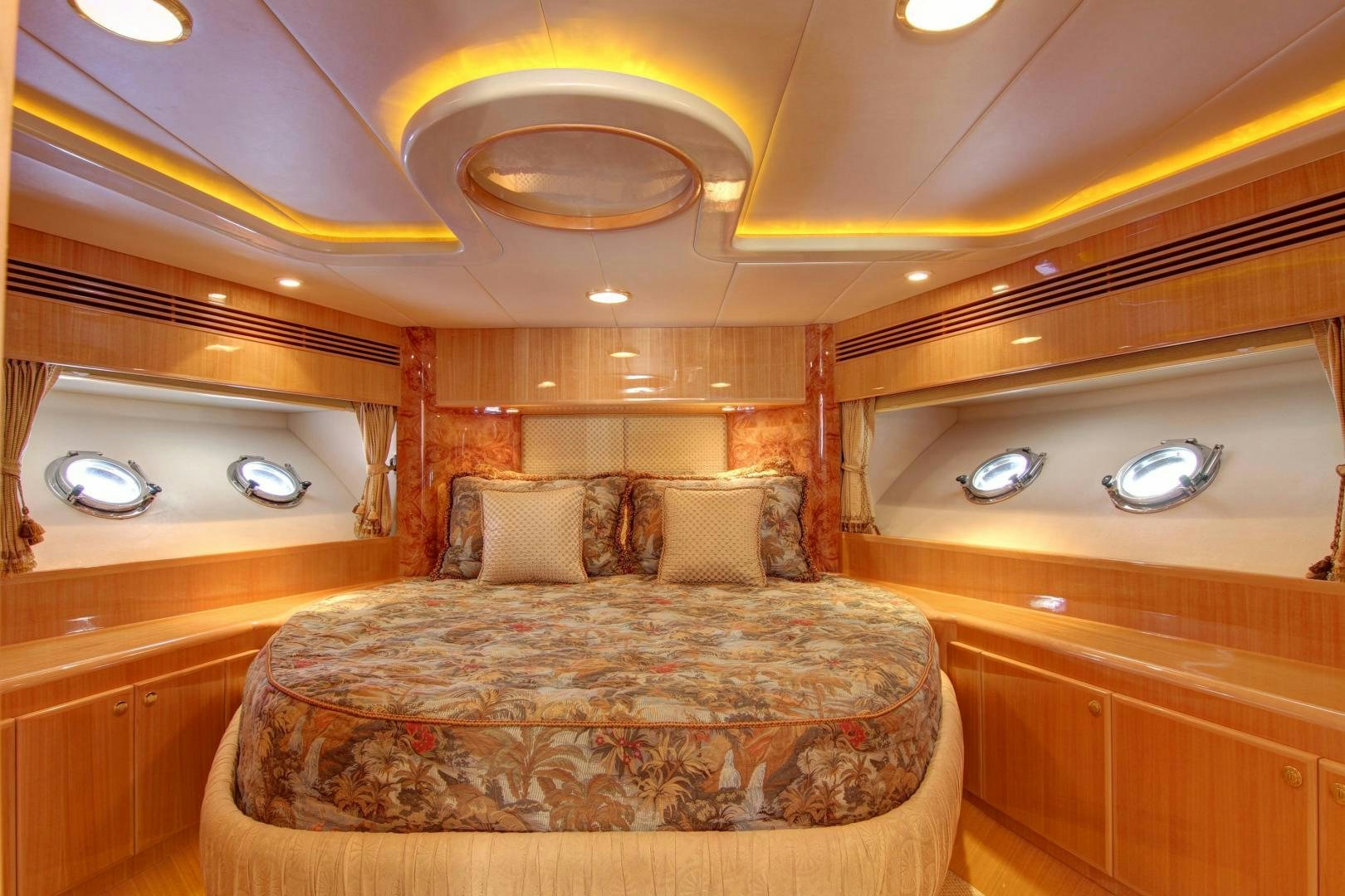 a room with a bed and a chandelier aboard UNSINKABLE II Yacht for Sale