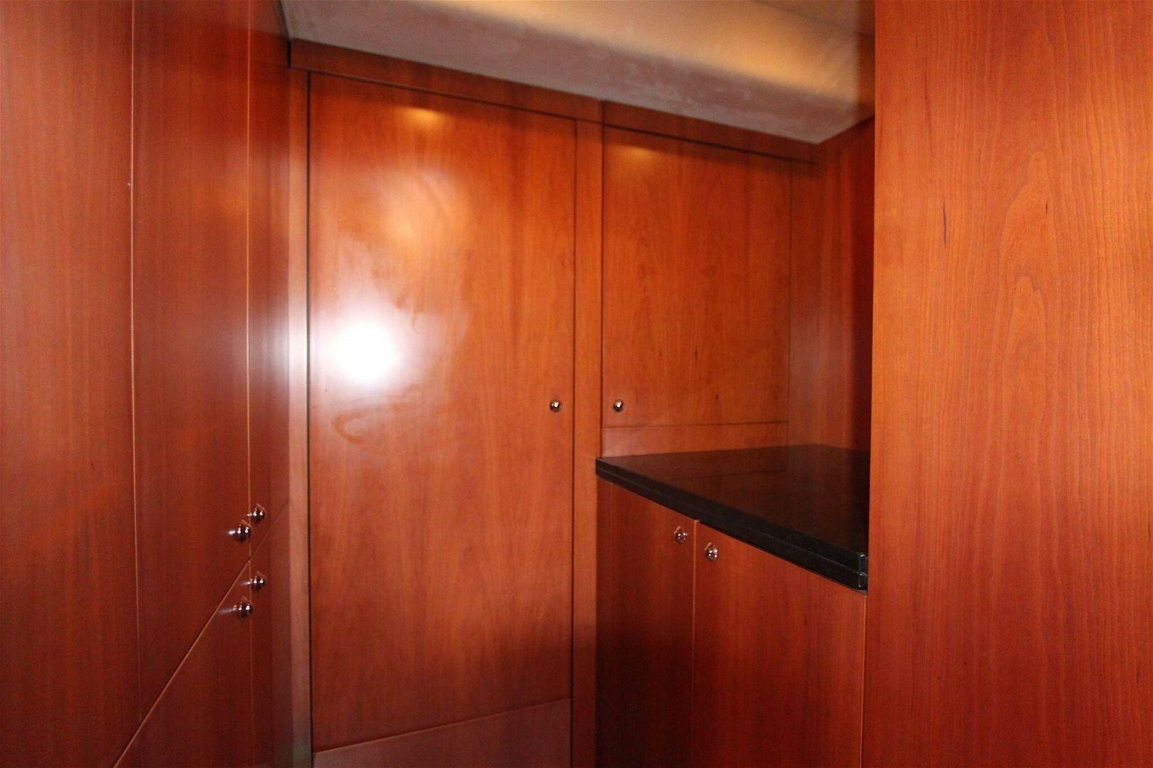 a wooden cabinet with a black counter aboard No Name Yacht for Sale