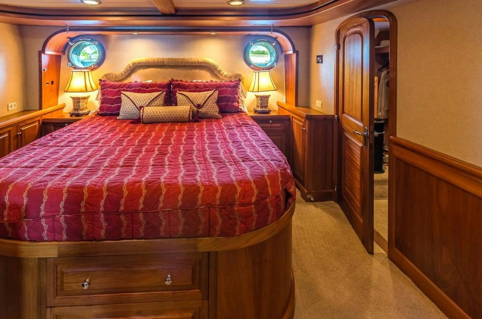 a bed with a red comforter aboard HERCULES Yacht for Sale