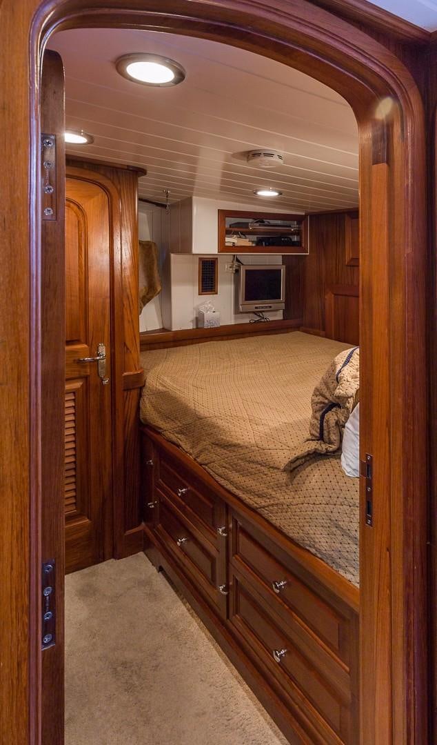 a bedroom with a bed and a wood closet aboard HERCULES Yacht for Sale