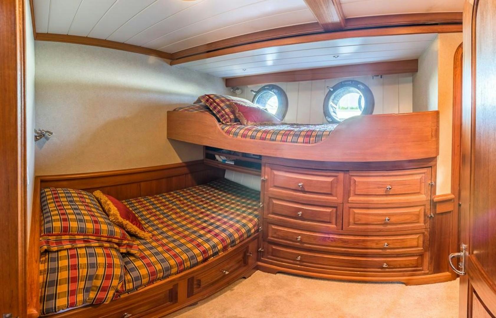 a bed with a wooden headboard aboard HERCULES Yacht for Sale