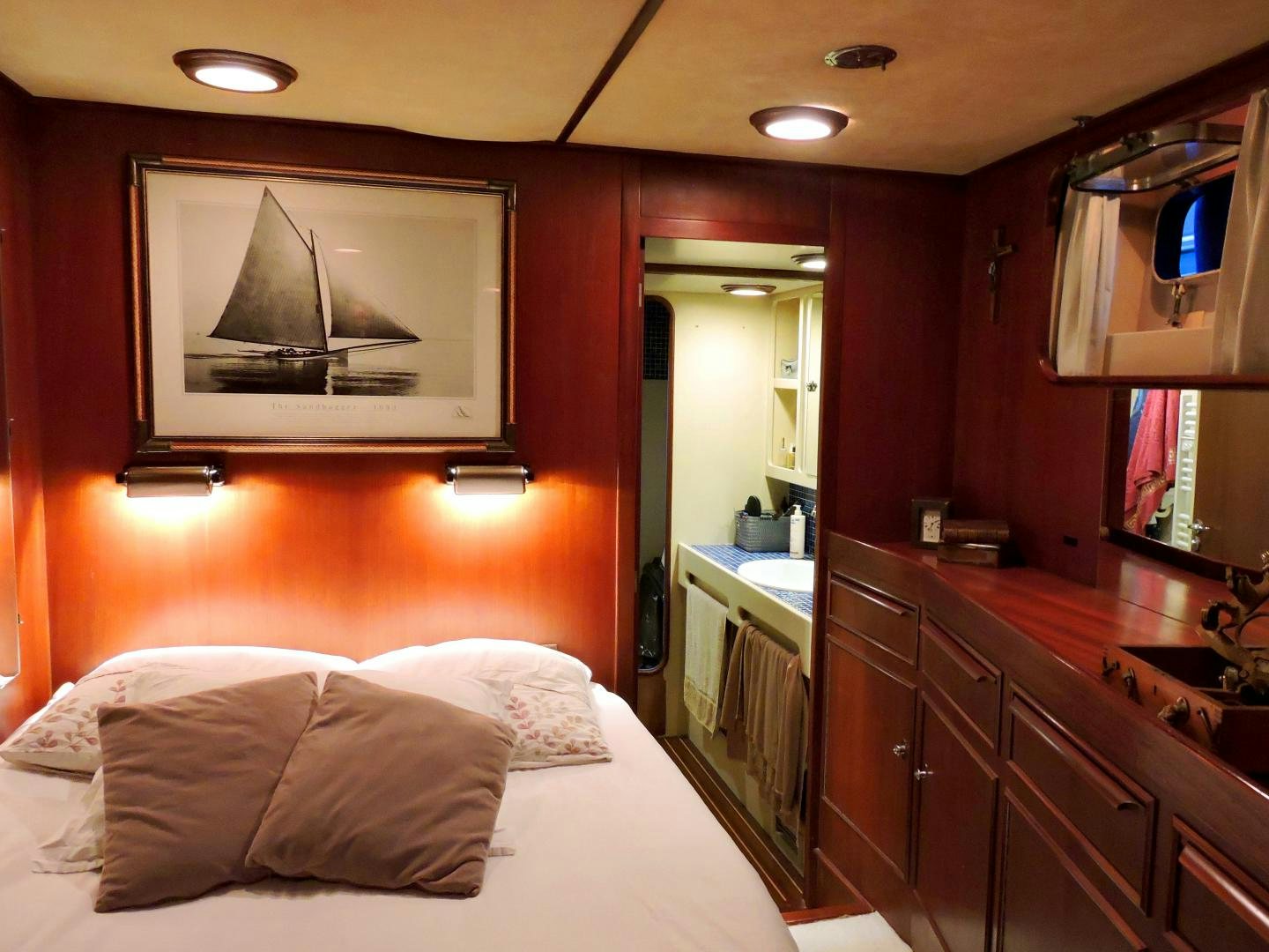 a bedroom with a large mirror above a bed aboard WHITE GARUDA Yacht for Sale