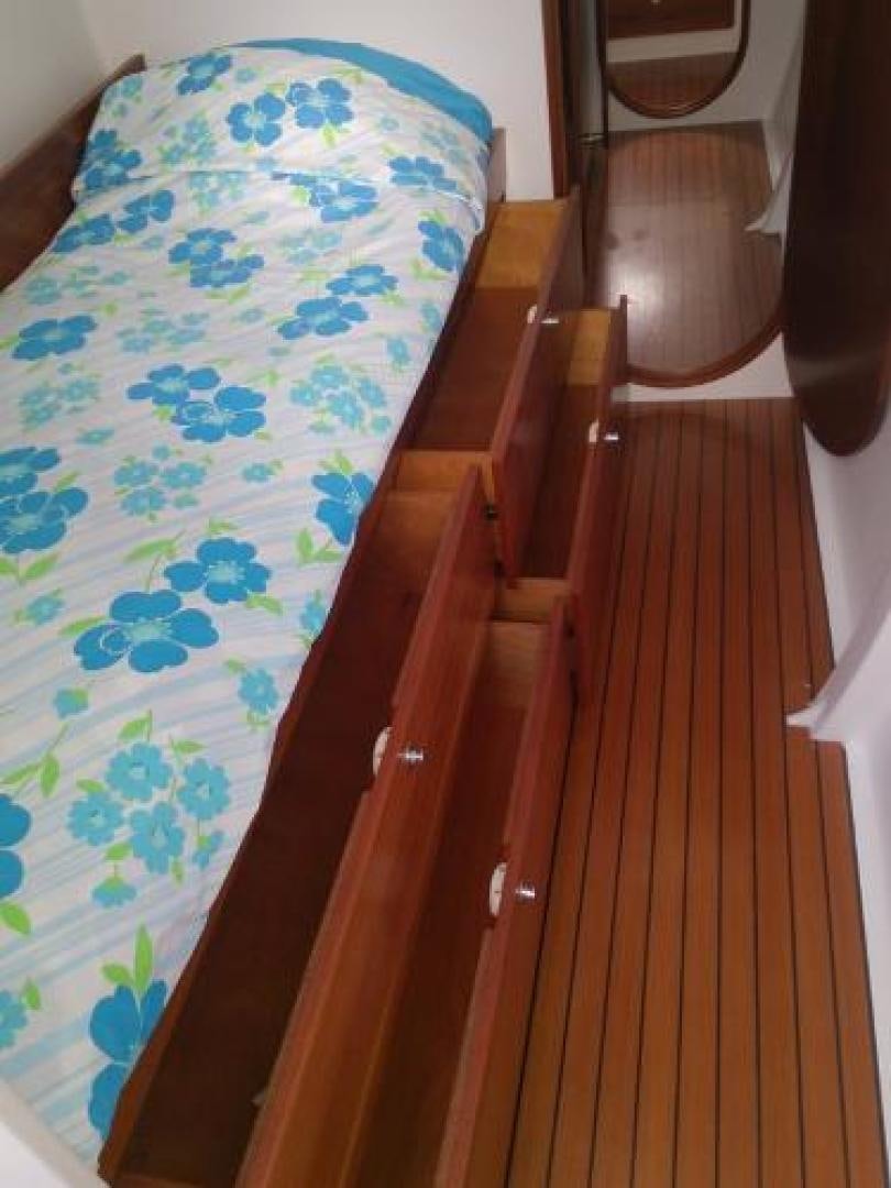 a bed with a blue sheet aboard No Name Yacht for Sale