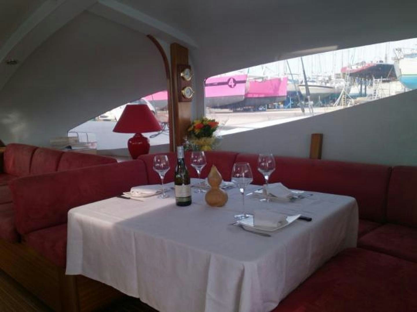 a table with wine glasses and bottles on it aboard No Name Yacht for Sale