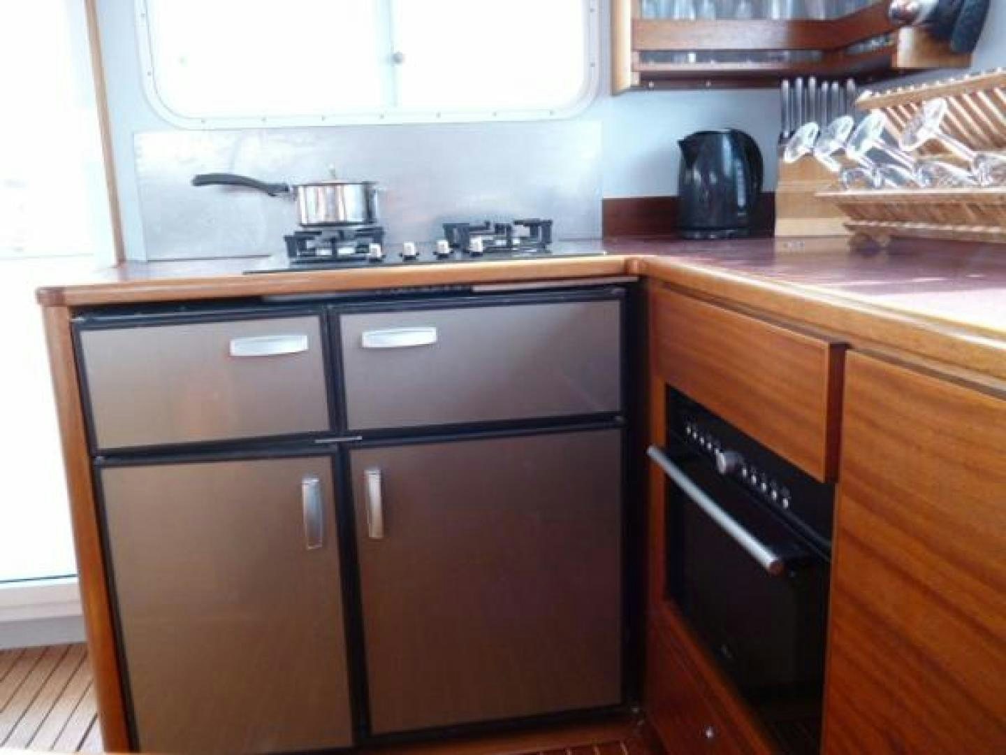 a kitchen with wooden cabinets aboard No Name Yacht for Sale