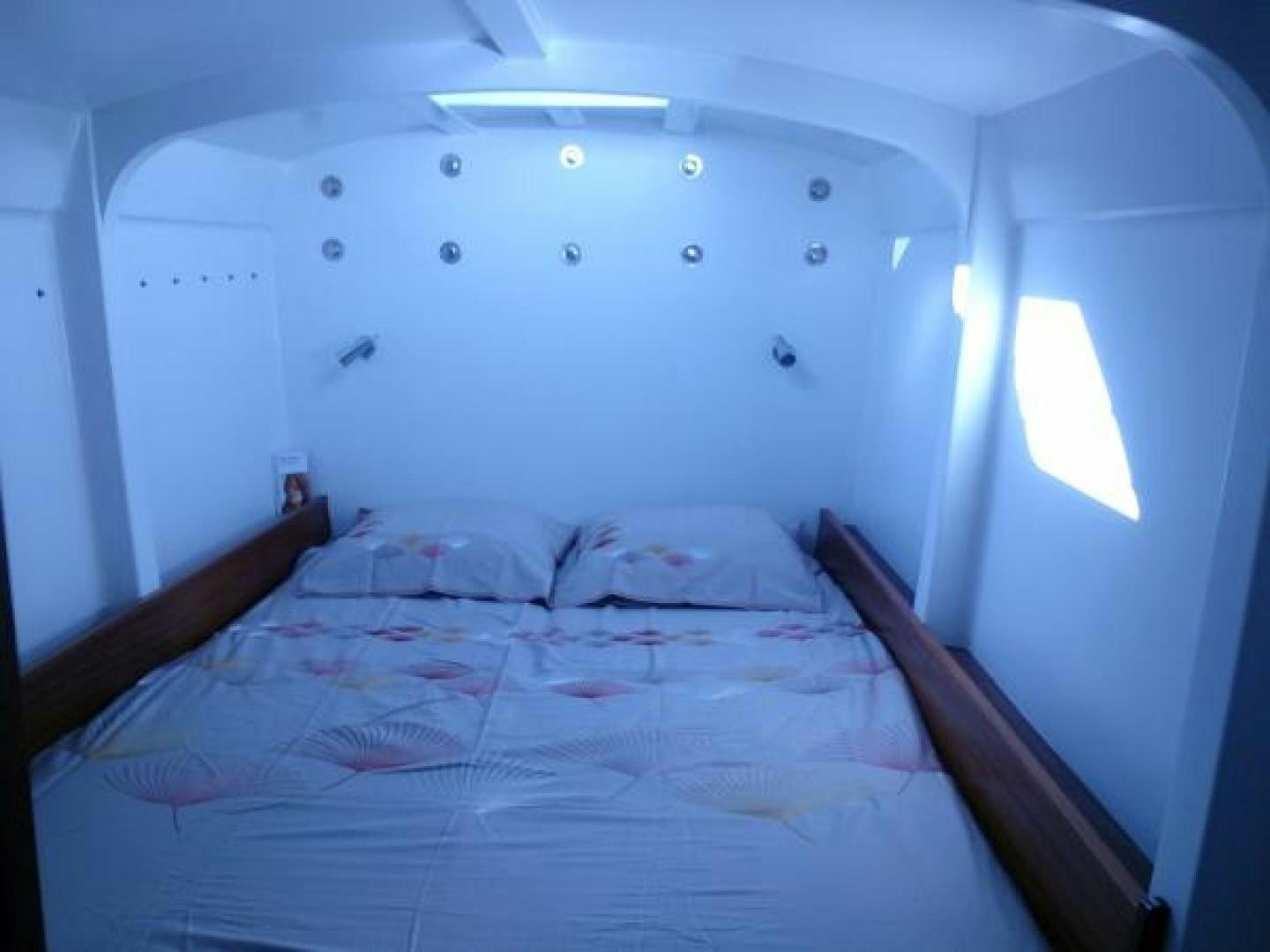 a bed with a white sheet aboard No Name Yacht for Sale
